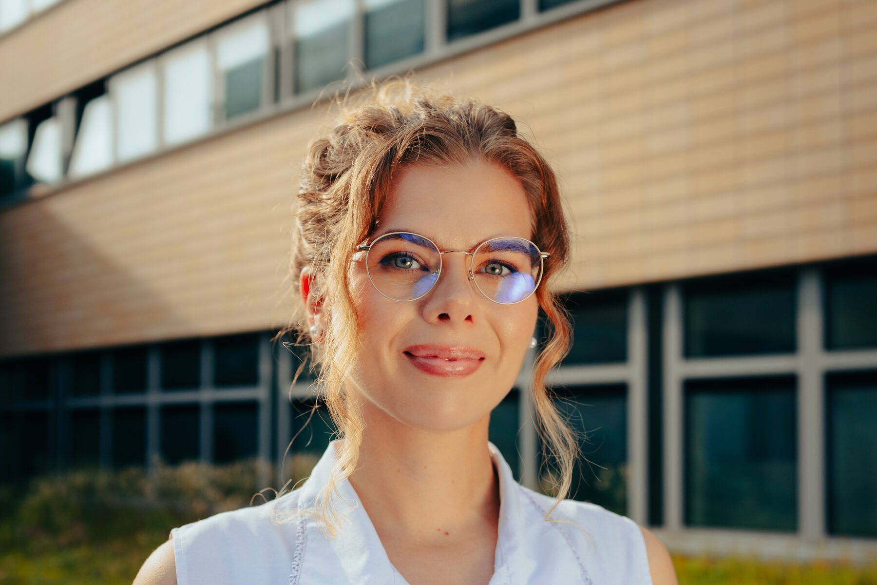 Annie mit Brille vor dem Hochschulgebäude