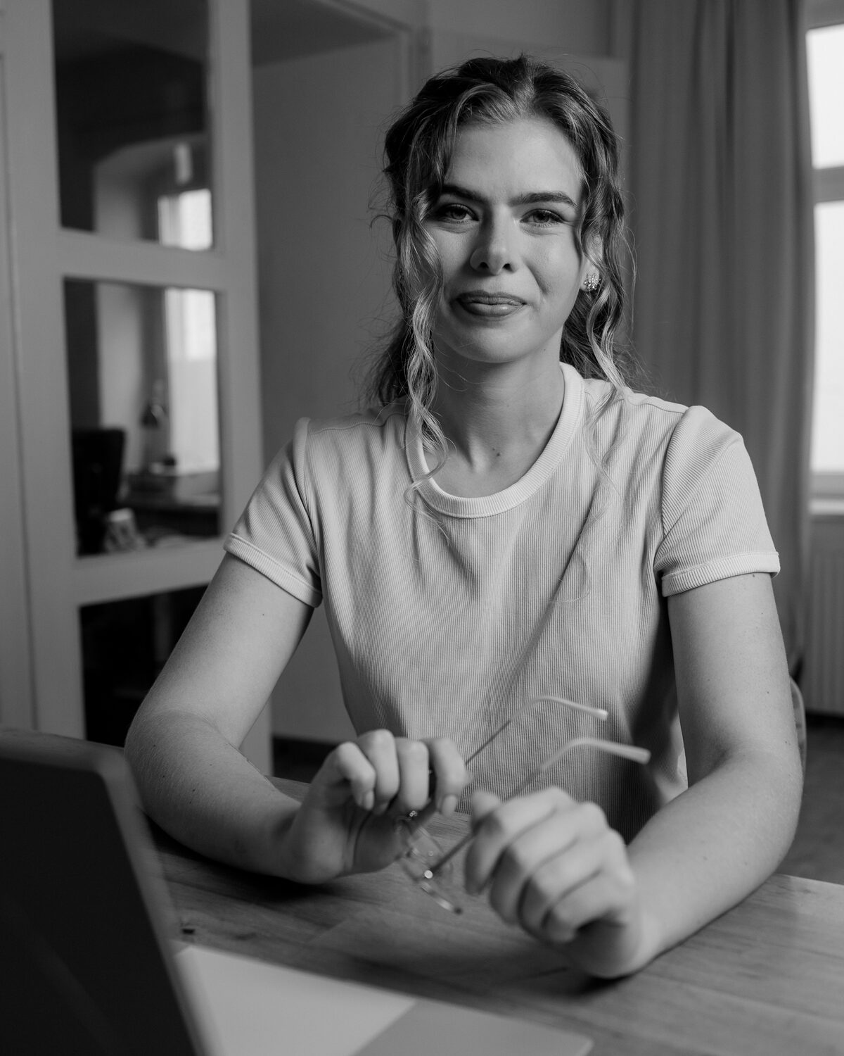 Annie am Laptop, Brille in der Hand