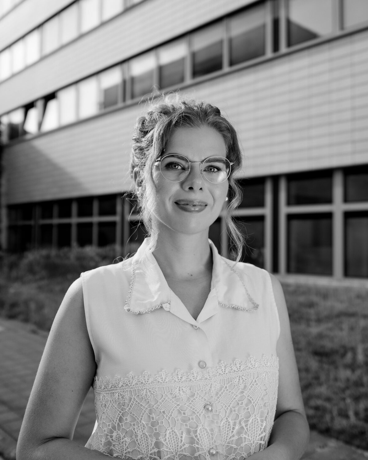 Annie mit Brille vor dem Hochschulgebäude