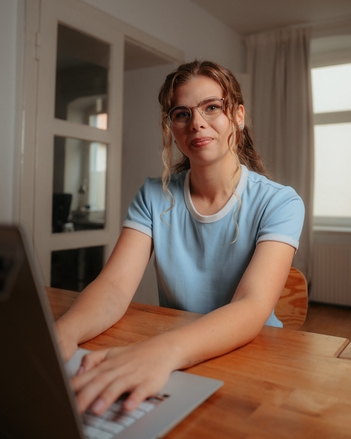 Annie mit Brille am Laptop, im Gespräch