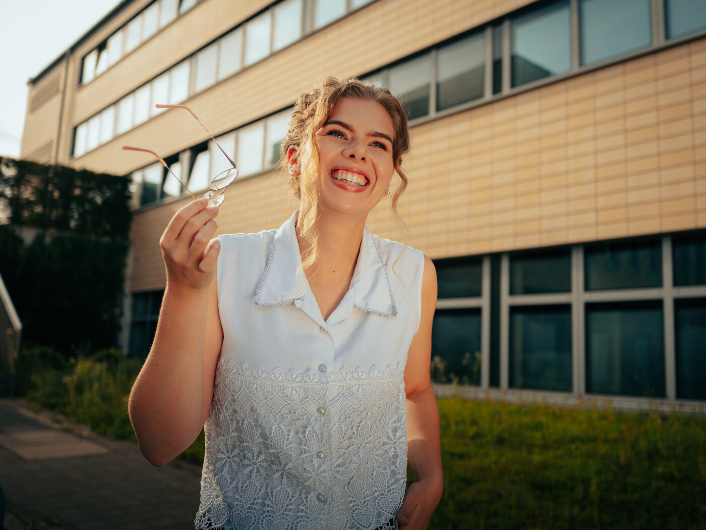 Annie im Freien vor dem Hochschulgebäude, lachend